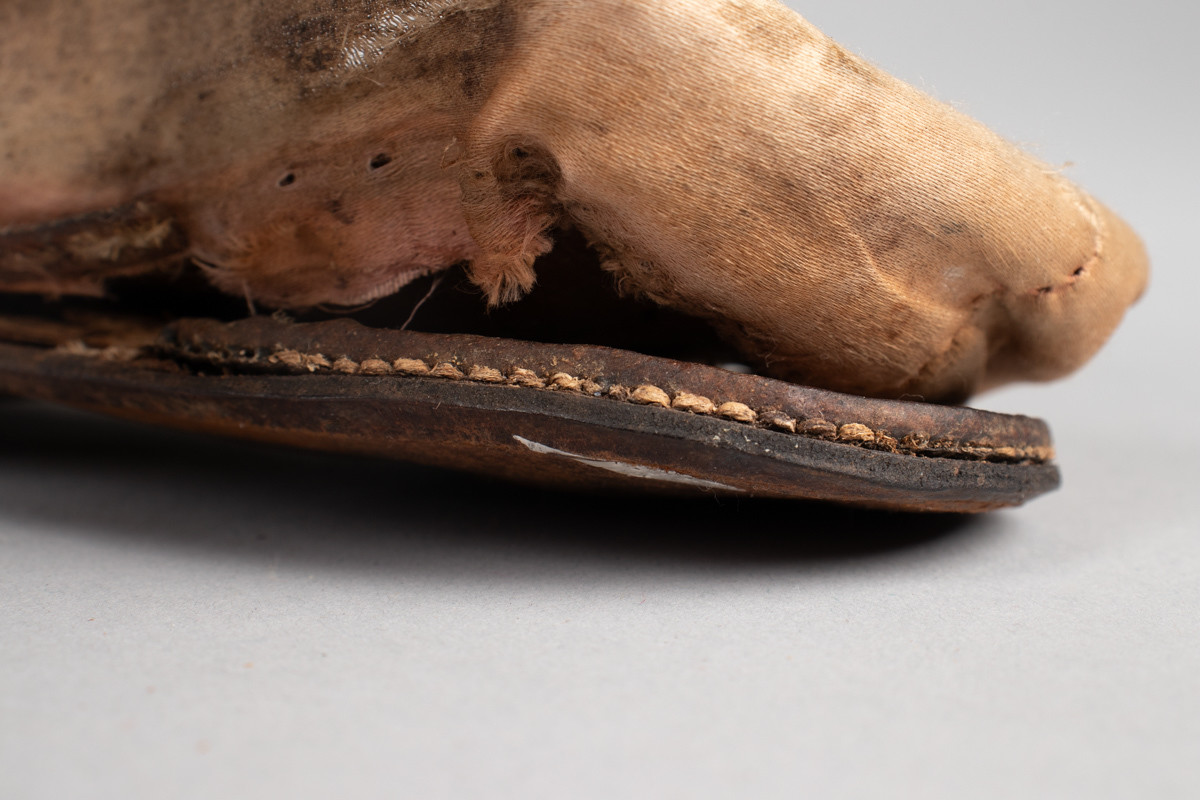 Rosa, håndsydd damesko eller tøffel i silke med spiss tå og flat lærsåle uten hæl. Dekorert med rosett med paljetter på rista.