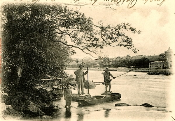 Brevkort, "Laxmetare. Falkenberg." Två män och en pojke vid Ätrans södra strand med metspö, håv och en laxeka. På andra sidan ån syns delar av Falkenberg.
(Bild 2 visar meddelandet, som skrevs på kortets framsida fram till 1905, och bild 3 bildens toning)