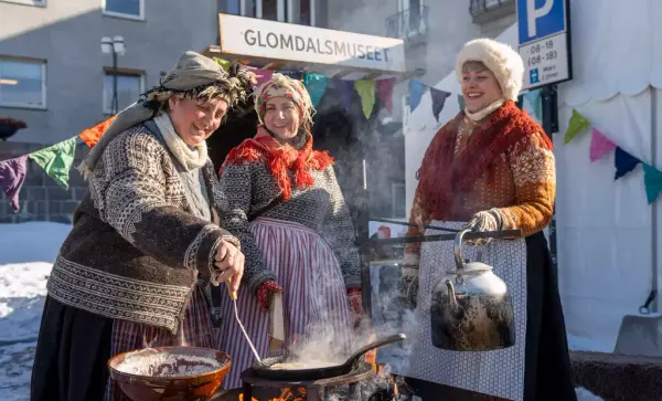 Tre glade damer koker kaffe på bål under Grundsetmartn.