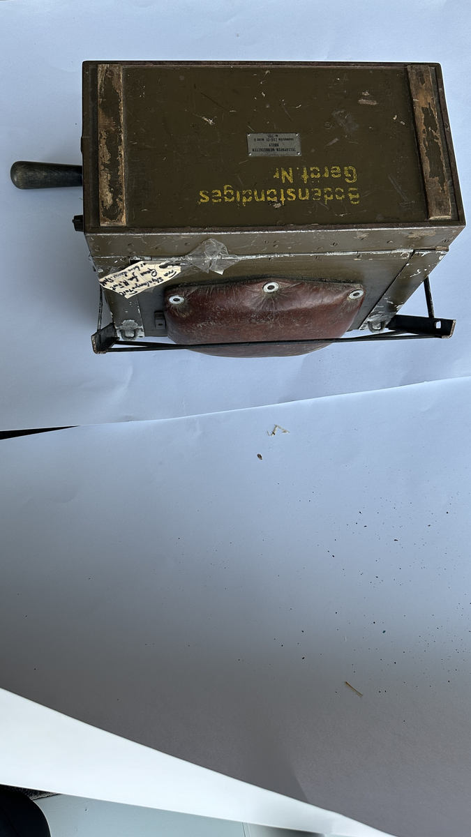 Tysk feltapparat med sveiv. Voltmeter. Skuff med ekstra pærer. Trolig mulighet for å lade et batteri.