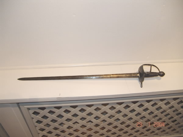 Värja, kommisvärja (ursprungligen modell 1685). 1832 ändrad till huggare för flottan. Kavelns lindning av svärtad järntråd. 