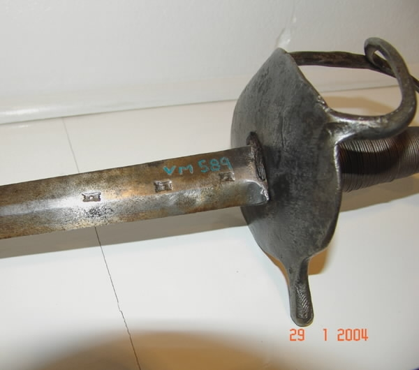 Värja, kommisvärja (ursprungligen modell 1685). 1832 ändrad till huggare för flottan. Kavelns lindning av svärtad järntråd. 