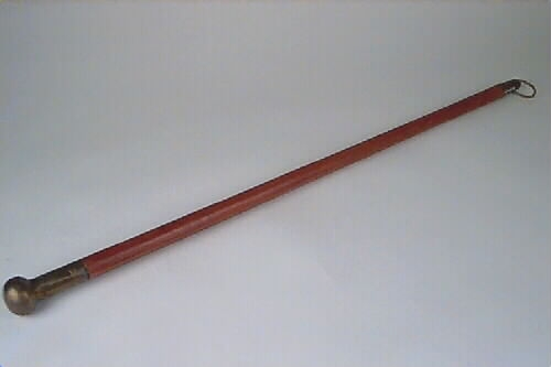 Käppen kan ha använts som piska. Knoppen är av mässing med enkla linjer och vågig kant som dekoration. I nedre änden sitter en ögla som kan vara till för fastsättning av snärt.