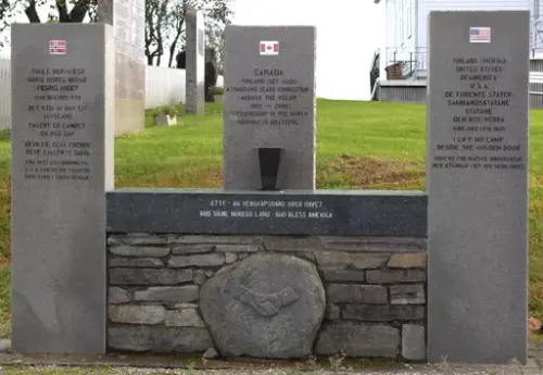 Hovudmonunentet, tre søyler, USA, Norge, Canada, i sokkelen rund stein med relifeff av håndtrykk 