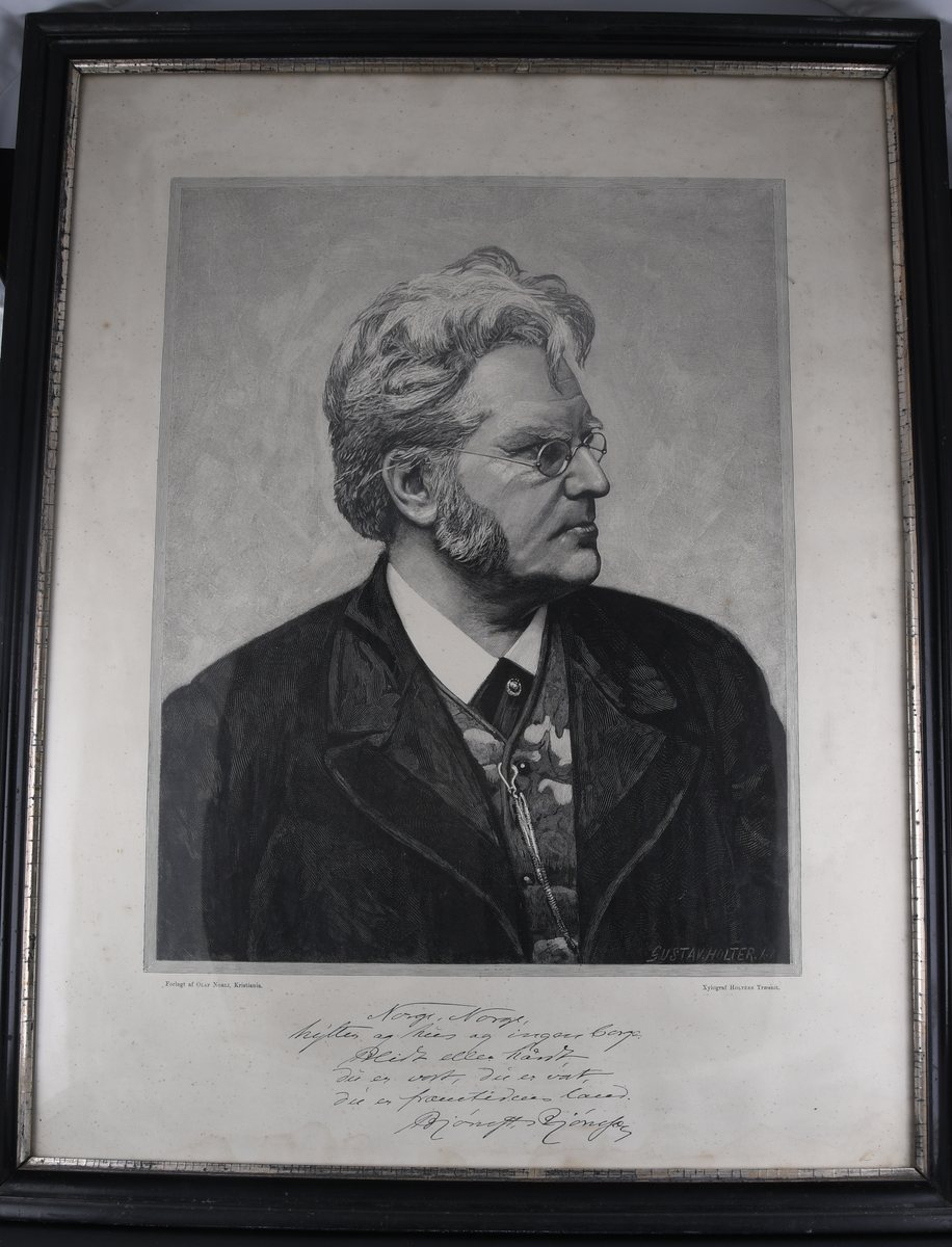 Stående rektangulært bilde. Motiv av Bjørnstjerne Bjørnson i sideportrett, med utdrag fra diktet Norge, Norge! Bildet har svart, profilert ramme med sølvfarget parti innerst på rammen.