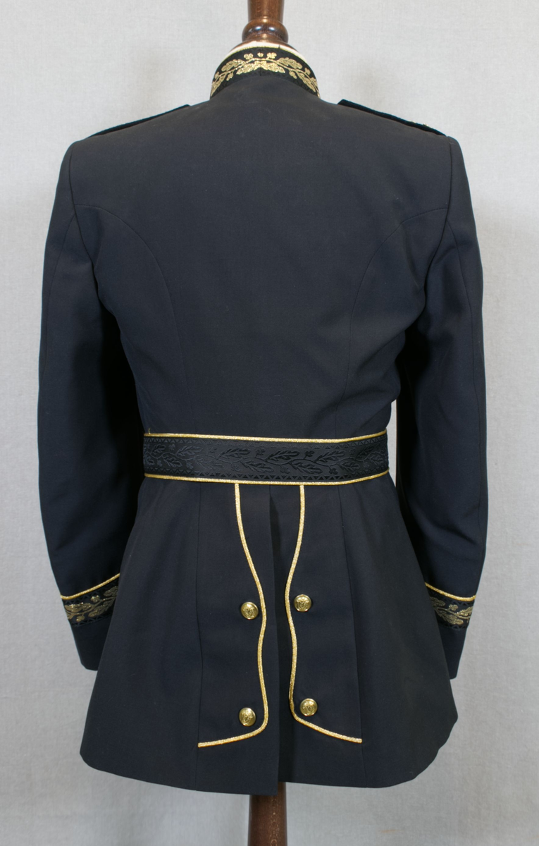 Foret, sort jakke med gullbrodert eikeløv med nøtter på krave og på ermer. 14 gullforgylte knapper i front, to på hvert erme og seks ved splitten bak. Gullkant langs hele fronten, på kraven på ermene og ved splitten. Epåletter i flettet gull med fire stjerner og eikeløv (politidirektør). Hvit løssnipp festet med borrelås.

Langt, sort skjørt med gullrender i sidene og glidlås bak.

Sort politilue med luemerke i gull og rødt og eikeløvsbroderier i sort og gull. To forgylte knapper holder luesnoren på plass.

Sort stoffbelte med gullkant innvevd mønster (eikeblad og sikksakkbord) Rektangulær beltespenne i gullforgylt metall med riksvåpen. Beltets lengde kan reguleres med borrelås på innsiden, og er nå 90 cm langt medregnet spennen.

Det hører til hvite hansker, men disse mangler.