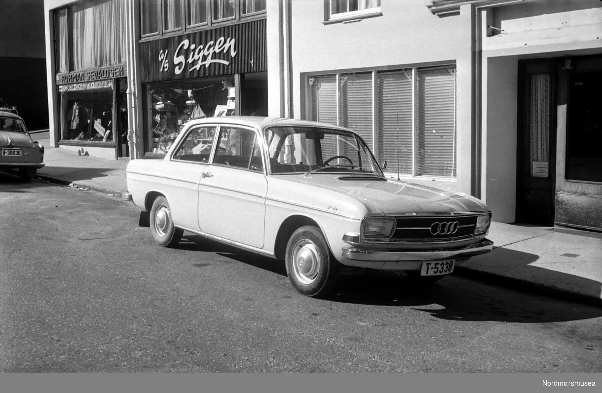 Foto av en Audi bil med registreringsskilt Audi T-5338 parkert utenfor A/S Siggen på Kirklandet i Kristiansund. Foto dateres til august 1966. Fra Romsdalspostens arkiv.