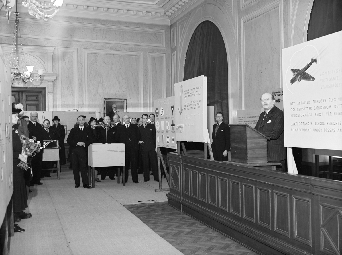 År 1940 och orostider i världen. I flygstaden Linköping var man inte minst orolig för luftangrepp, varför man i stadshuset anordnade en upplysande utställning om just luftskydd. I bildseriens första tagning ses landshövding Karl Tiselius inviga utställningen.