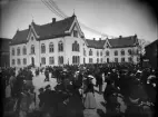 Ett något fördunklat ögonblick från Linköping 1901. Oklart även för vad som fick Linköpingsborna så mångtaligt på benen denna dag. Stadens läroverk i fonden och förekommande studentmössor i folkmassan gör något studentskt troligt.