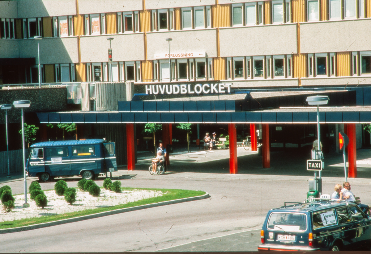 Entrén till Huvudblocket på Ril, Regionsjukhuset i Linköping. Utanför entrén ser man en taxi samt en Volvo. Ovanför entrén till Huvudblocket låg förlossningen. Idag kallas sjukhuset Universitetssjukhuset i Linköping.


Historik om sjukhuset:
Sjukhuset har sina rötter i Linköpings länslasarett, som grundades 1782, och låg mitt i centrala Linköping. År 1895 flyttades verksamheten till ett nybyggt sjukhus, då strax utanför staden, där US ligger i dag. Till följd av en nationell regionsjukvårdsutredning blev lasarettet 1960 Regionsjukhuset i Linköping ("RiL" i folkmun). Under åren 1965–1975 byggdes huvudblocket med flera större byggnader. 1992 byttes namnet till Universitetssjukhuset i Linköping (US). År 2011 startade en ombyggnation av US, den pågår fortfarande (år 2024).

Bilder från staden Linköping digitaliserade från diapositiv. Bilderna är från 1970-1990-talet.