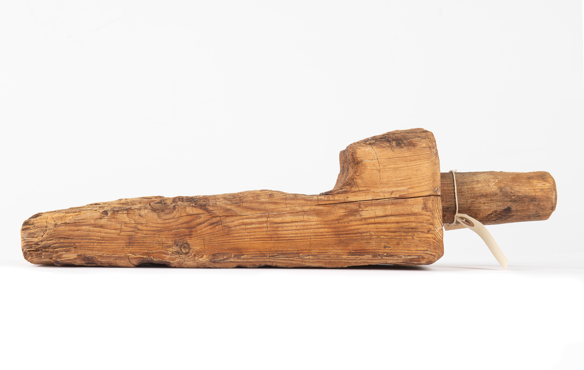 En kil med ett runt handtag som mäter 45 mm i diameter och är 105 mm långt. Ser ut som en kil.