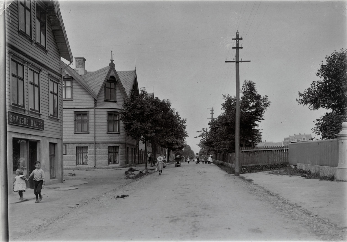 Bygate i Haugesund. Det er flere barn i gata. I huset til venstre holdt ...