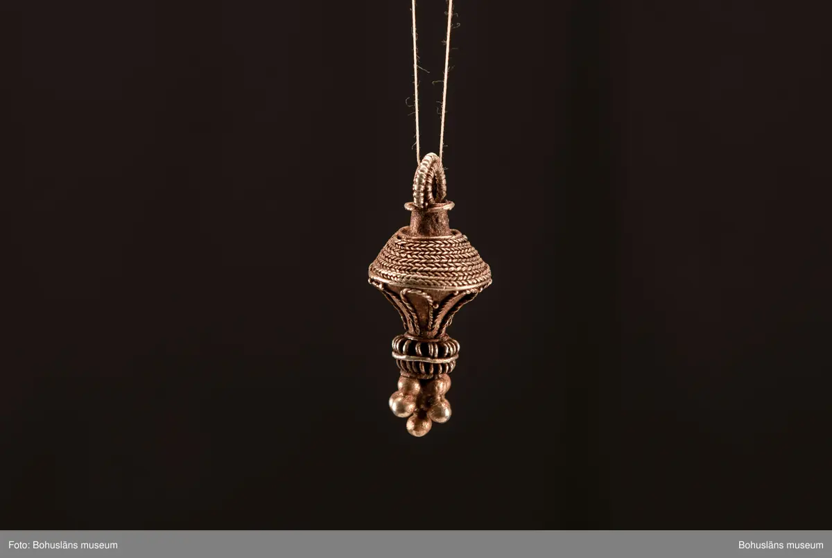 Ett utsökt intakt hängsmycke av guld, en s k päronformad berlock. Överst på hänget, finns en ögla för upphängning på ett band, halskedja eller liknande. Dekoren är utförd i s k filigranteknik, och visar på högt hantverksmässigt kunnande. Mycket tunna, tvinnade eller flätade guldtrådar är lagda ovanpå och runt hängets övre del. På hängets undre del är flera små runda guldkulor (granuleringar) fästade. Berlocken tillhör "typ III", enligt von Müllers typologi (se Müller 1958). Formmässigt har hänget sitt ursprung i östra Medelhavet och området kring Svarta havet.

Denna typ av hängsmycken är mycket ovanligt att hitta i våra trakter, det är endast en handfull som tidigare påträffats i Sverige och de flesta på Öland. Desto fler har däremot hittats i Danmark (se Rapport 2020:166, s.12).

Hänget/berlocken hittades, tillsammans med fyra spännen av brons, ett 40-tal keramikskärvor, brända och obrända ben, däribland en tand, flintavslag och bitar av en dekorerad kam av horn. Graven innehöll två individer. Den ena var jordlagd utan kremering och den andra kremerad. Den jordlagda individen hade endast ett fåtal ben och tänder bevarade. De visade sig tillhöra en ung person, ca 16-20 år gammal. Förmodligen en kvinna, vilket de gravgåvor som var nedlagda i graven visade.
Den andra individen, till vilken de brända benen hörde, var även det en ung person. 
För mer info om, och tolkning av fyndet se rapport Arkeologerna 2020:166.