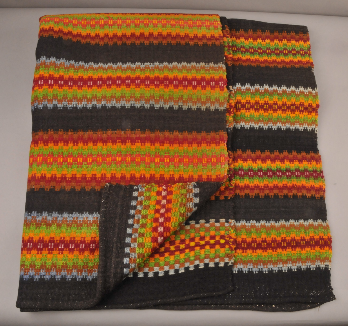 Dobbel krokbragd, 3 skaft.
Renning, 35/10 cm
Innslag av tykt ullgarn, pakkelita 
Svart botn, 11 mønsterstriper 
Stripene er 11-13 cm breie
Fargane blir kalla "Tuddal-fargar" ved registrering av A.Jantzen i 1981