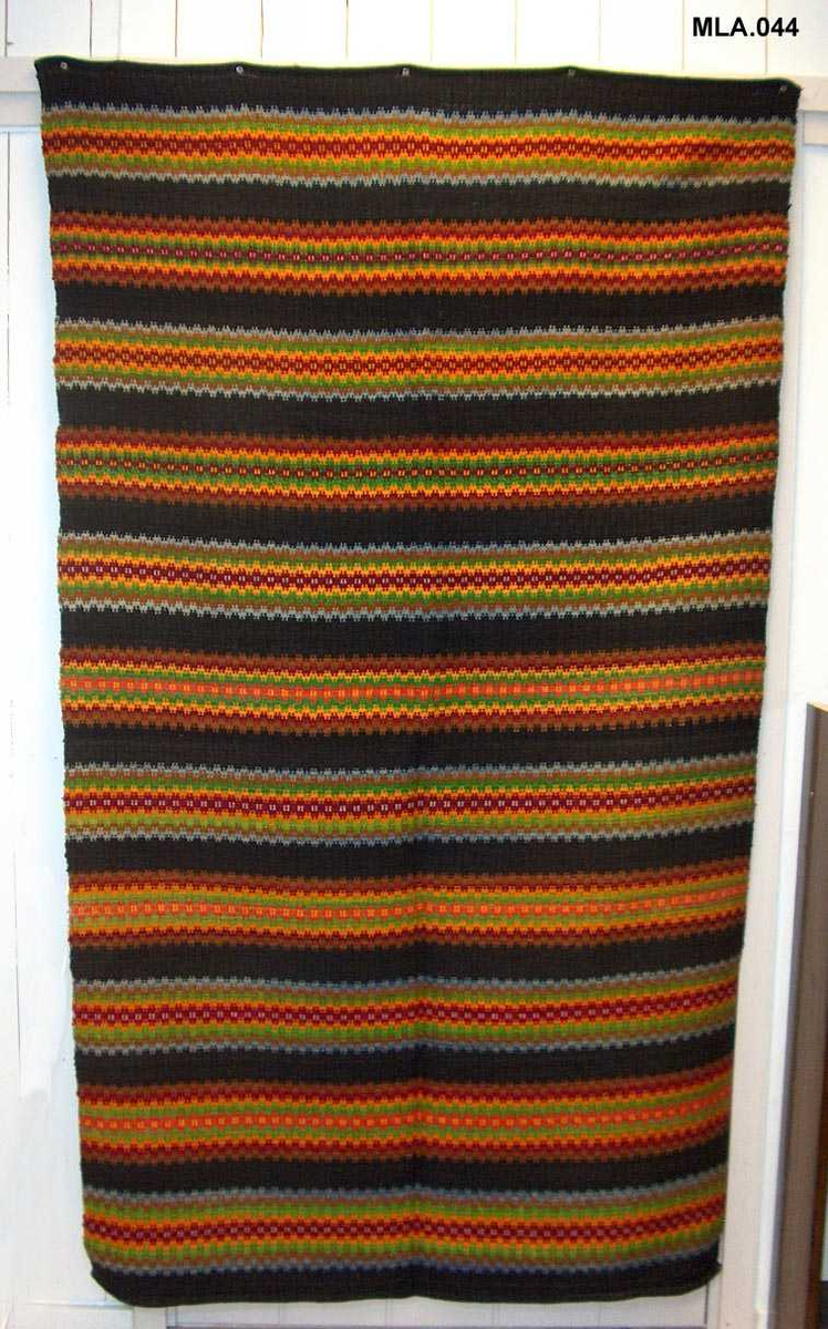 Dobbel krokbragd, 3 skaft.
Renning, 35/10 cm
Innslag av tykt ullgarn, pakkelita 
Svart botn, 11 mønsterstriper 
Stripene er 11-13 cm breie
Fargane blir kalla "Tuddal-fargar" ved registrering av A.Jantzen i 1981