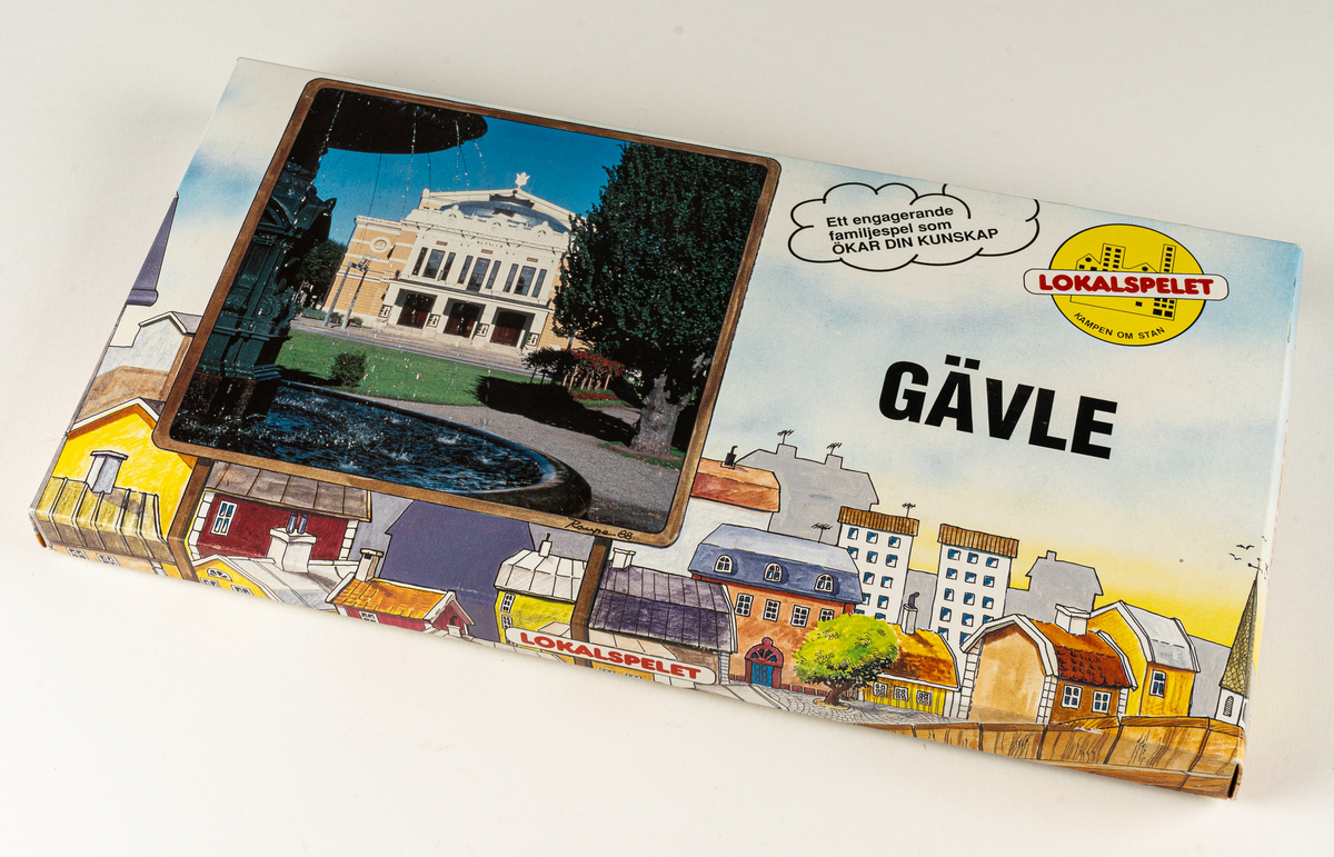 Sällskapsspel i kartong, innehållande spelplan med karta över Gävle, tärningar och spelpjäser i trä samt olika spelkort. 
I locket spelregler för LOKALSPELET GÄVLE.