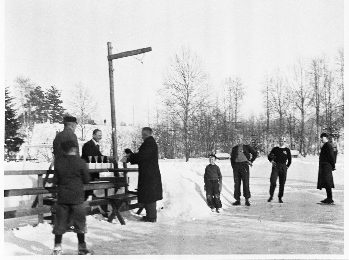 Fra premieutdelingen.  Kjøpmann Arnesen deler ut premiene, verdensmester Peter Sinnerud tar i mot.
Alfred Balke til venstre, skøyteløper H. Engnestangen, M. Staksrud og Odd Lundberg.