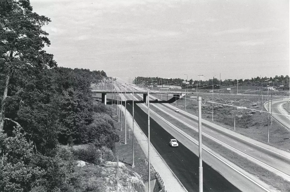 Väg 222, Värmdöleden med avfarten mot Saltsjöbadsleden. I bakgrunden till höger skymtar Skogalund och klippan där bostadsområdet Skogalundsklippan, även kallat Västra Skogalund, senare uppfördes. Bakom Saltsjöbadsledens viadukt öppnade senare Nacka Trä, sedermera Bygg Ole och där skymtar även OK-bensinmacken.