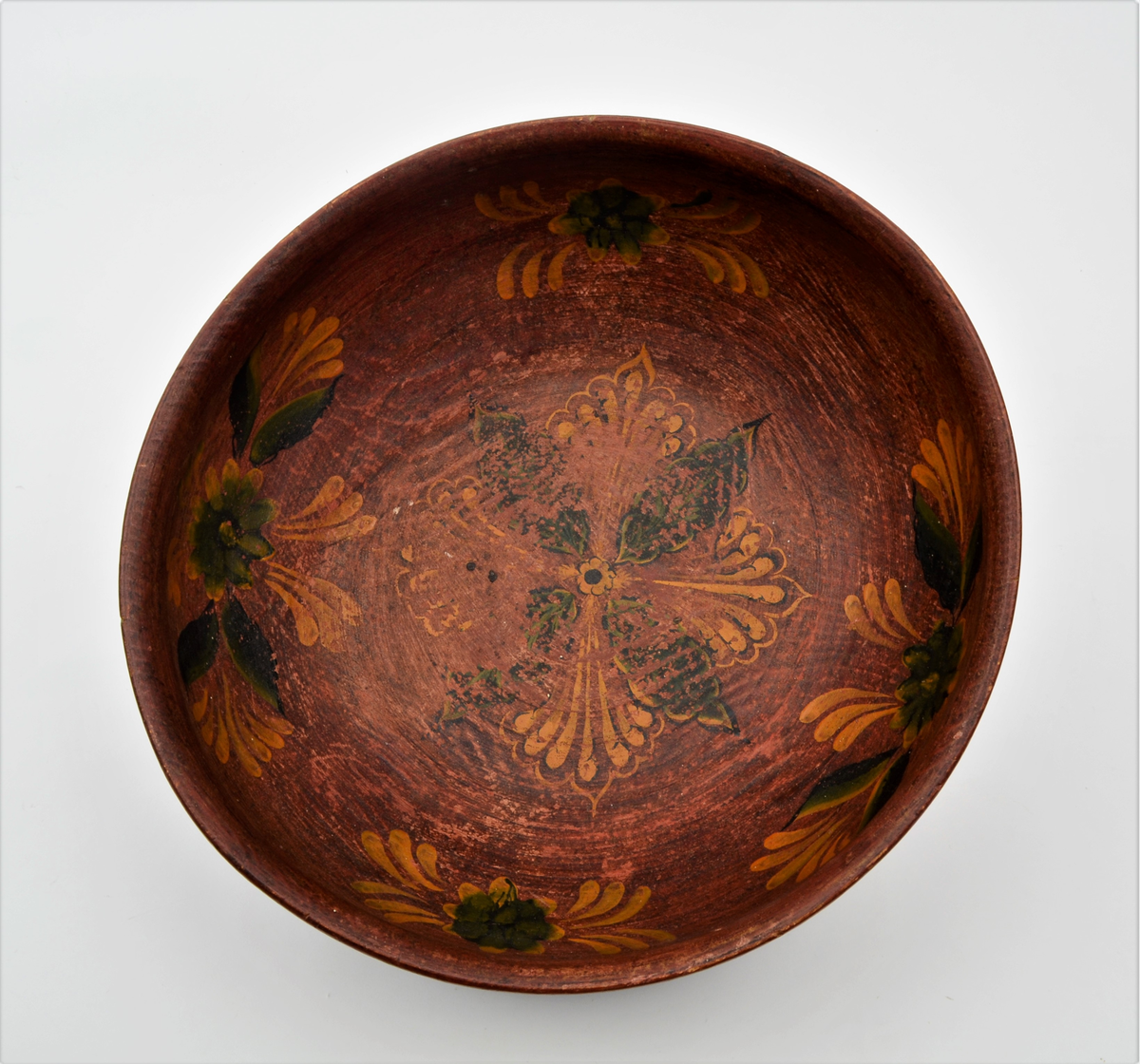 Frå Martin Sælid sin handskrivne katalog:
"Ølbolle av bjørk, 34 cm frå bradd til bradd og 16 cm høg. Den er måla brunraud innvendig med ei stor ros i botnen og fire kvar for seg sjølvstendige roser i sida. På utsida er han måla mørkgrøn (virka nesten svart..) opp til ei bord med fire render rundt. Derfrå og til ei ny rand, der innsvingningen tek til 3,5 cm er lakt 10 mørke snorer [teikning] i målinga og milom desse er det mørk grøn farge med spetter av gullbronse. Feltet opptil kanten som er 3,3 cm er brunraudt eller mørkraudt med gulraud innskripsjon som lyder slik: Drik min ven naar Ølet bliver ende saa Brygger jeg igen. Endre Østensen L. 1831. Bollen har tilhørt Endre Østensen Lansrud i Slidre født 1827.36,3 Eg kjøpte den på auksjon på Nordviste i Røn etter Endre I Nordviste"