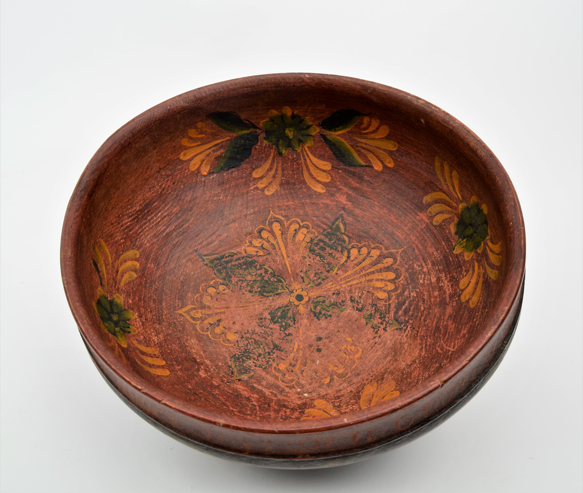 Frå Martin Sælid sin handskrivne katalog:
"Ølbolle av bjørk, 34 cm frå bradd til bradd og 16 cm høg. Den er måla brunraud innvendig med ei stor ros i botnen og fire kvar for seg sjølvstendige roser i sida. På utsida er han måla mørkgrøn (virka nesten svart..) opp til ei bord med fire render rundt. Derfrå og til ei ny rand, der innsvingningen tek til 3,5 cm er lakt 10 mørke snorer [teikning] i målinga og milom desse er det mørk grøn farge med spetter av gullbronse. Feltet opptil kanten som er 3,3 cm er brunraudt eller mørkraudt med gulraud innskripsjon som lyder slik: Drik min ven naar Ølet bliver ende saa Brygger jeg igen. Endre Østensen L. 1831. Bollen har tilhørt Endre Østensen Lansrud i Slidre født 1827.36,3 Eg kjøpte den på auksjon på Nordviste i Røn etter Endre I Nordviste"