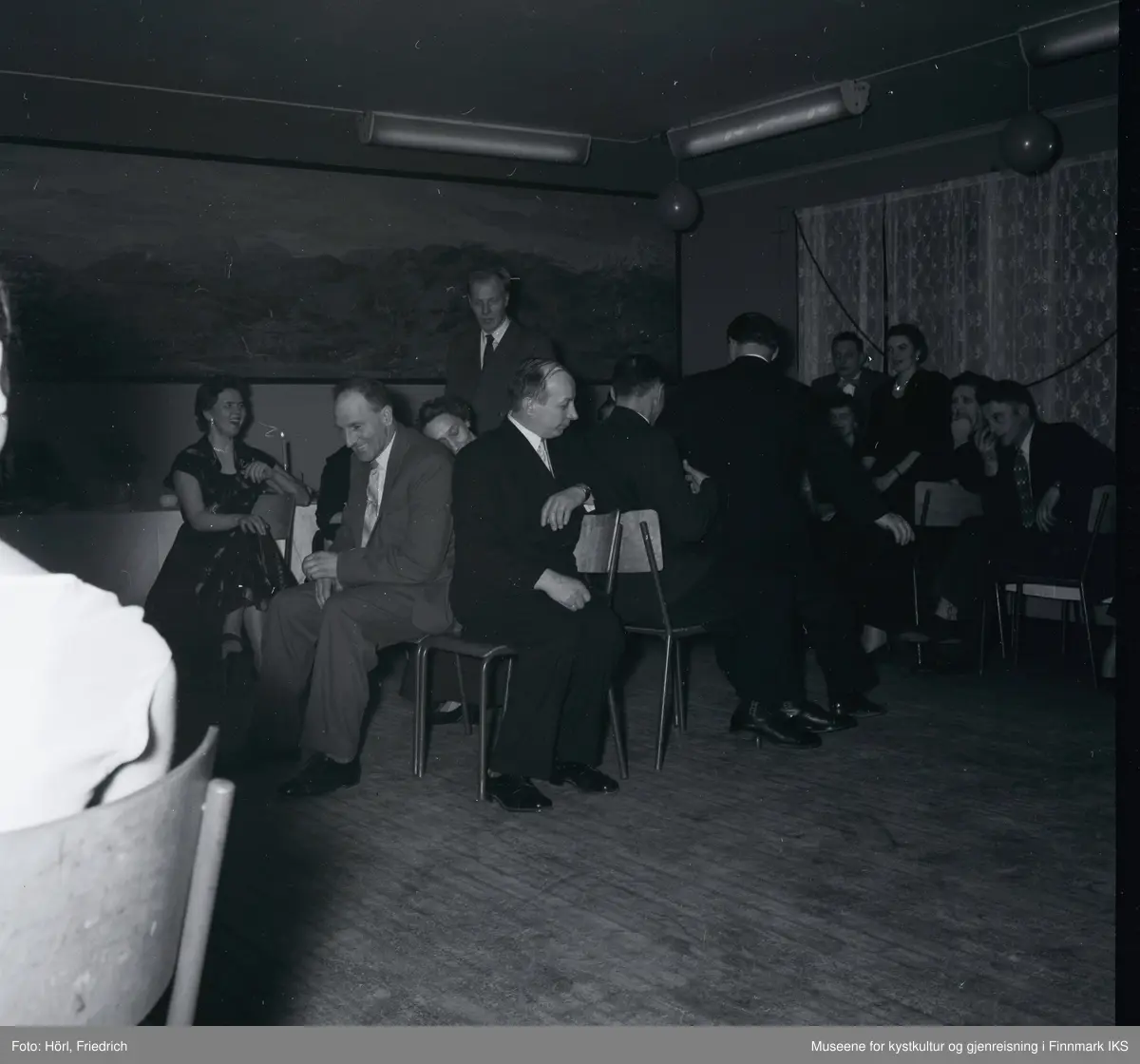På juletrefest til den katolske menigheten i Hammerfest i 1957 deltar de voksne i stolleken, også kjent som "Reisen til Jerusalem". Stemningen er god og mange ler. Rommet er pyntet med luftballonger.