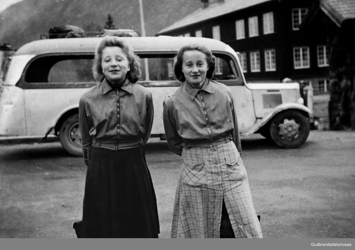 F.v.: Arnfrid Lund (f. 1927 g. Stener Olsen) og Olga Lund (f. 1925 g. Dalen) framfor skulebussen ved Loar skule