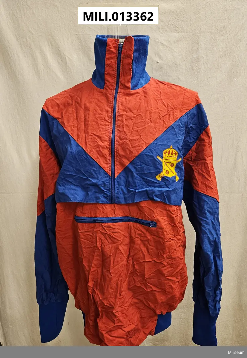 Träningsoverallsjacka med Smålandsbrigadens emblem på bröstet och text Smålandsbrigaden Eksjö på ryggen. Storlek L.