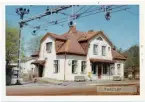 Vy vid Veddige. Station anlagd 1880. Tvåvånings stationshus, putsat byggt 1920 enligt arkiterk Harald  Söderberg, Varberg. Elektrisk växelförregling.