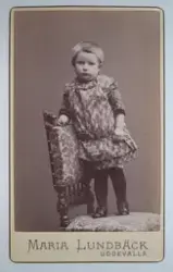 Visitkortsporträtt av okänt barn. Fotografiet sitter i fotoa