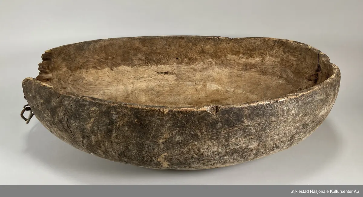 Ovalt salttraug av uthulet rirkule i bjørk. Delvis ødelagt på ene siden, stor bit falt av, eldre skade. Påmontert et håndtak i metall (nyere). Har vært hank på andre siden også, men dette er det bare rustne rester igjen av. Tydelige spor av grov rasp på utsiden av karet/trauget. Iflg giver ble dette karet brukt til å legge kjøtt på saltlake, for langtidsoppbevaring og foredling etter slakting.