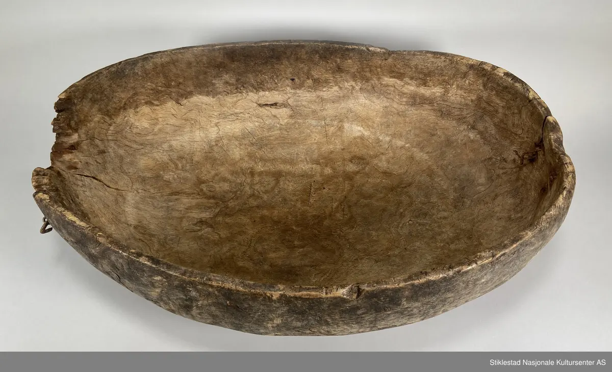 Ovalt salttraug av uthulet rirkule i bjørk. Delvis ødelagt på ene siden, stor bit falt av, eldre skade. Påmontert et håndtak i metall (nyere). Har vært hank på andre siden også, men dette er det bare rustne rester igjen av. Tydelige spor av grov rasp på utsiden av karet/trauget. Iflg giver ble dette karet brukt til å legge kjøtt på saltlake, for langtidsoppbevaring og foredling etter slakting.