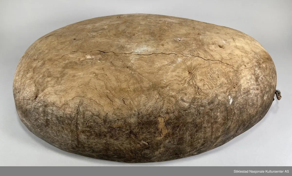 Ovalt salttraug av uthulet rirkule i bjørk. Delvis ødelagt på ene siden, stor bit falt av, eldre skade. Påmontert et håndtak i metall (nyere). Har vært hank på andre siden også, men dette er det bare rustne rester igjen av. Tydelige spor av grov rasp på utsiden av karet/trauget. Iflg giver ble dette karet brukt til å legge kjøtt på saltlake, for langtidsoppbevaring og foredling etter slakting.