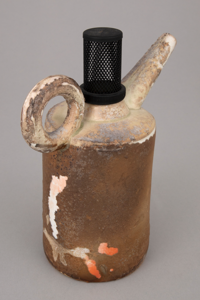 Installasjon med seks polykrome kanner i håndbygd porselen på et rustent bord med glassplate. Kannene er glasert og vedfyrt. Korkene på fem av kannene er lagd av funne komponenter. En har en korkopptrekker, to har industrielle komponenter i lakkert stål og to har gummikomponenter.