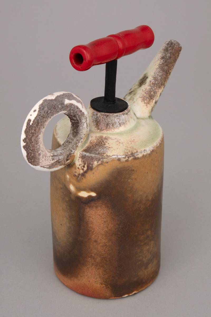 Installasjon med seks polykrome kanner i håndbygd porselen på et rustent bord med glassplate. Kannene er glasert og vedfyrt. Korkene på fem av kannene er lagd av funne komponenter. En har en korkopptrekker, to har industrielle komponenter i lakkert stål og to har gummikomponenter.