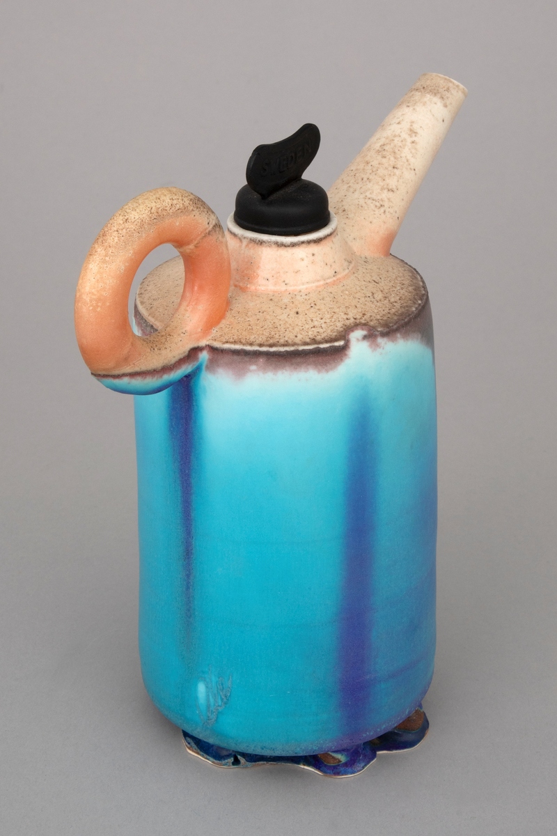 Installasjon med seks polykrome kanner i håndbygd porselen på et rustent bord med glassplate. Kannene er glasert og vedfyrt. Korkene på fem av kannene er lagd av funne komponenter. En har en korkopptrekker, to har industrielle komponenter i lakkert stål og to har gummikomponenter.