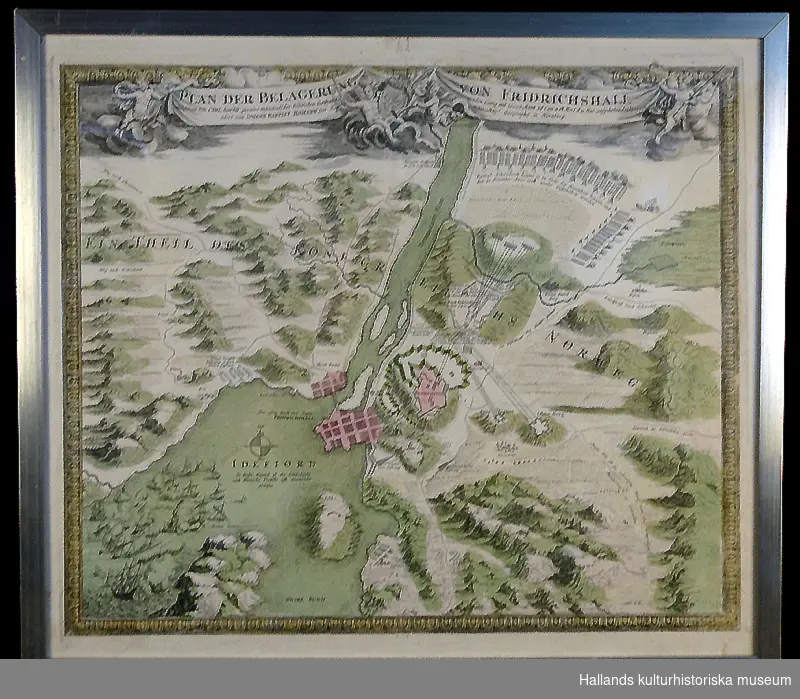 a) Kopparstick. "Plan der Belagerung von Fridrichshall". Plan över Fredrikstens fästning med omnejd vid Karl XII:s och de svenska truppernas belägring 1718. Akvarellerad i rosa, grönt och gult. Glasad. b) Ram av trä. Mått: bredd 2 cm.