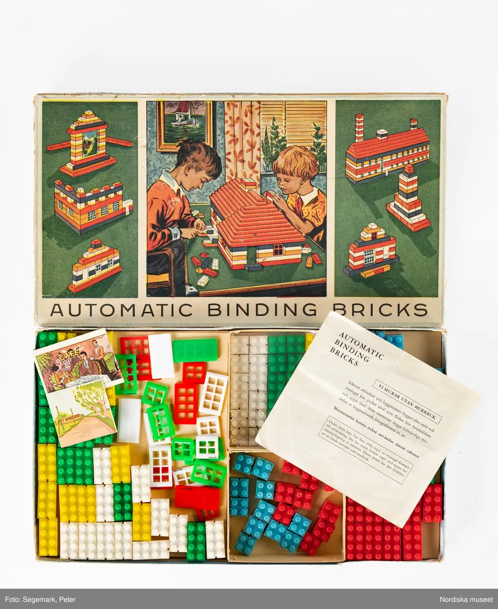 Enligt katalogkort:
Originalförpackning med Automatic Binding Bricks, med 59 hela och 60 halva byggbitar av plast i färgerna grönt, vitt, gult, blått och rött. 6 fönster med med 8 rutor, 6 fönster med 6 rutor, 6 fönster med 4 rutor, 4 dörrar, 2 motiv tryckta på kartong (landskap samt caféinteriör). 

Medföljande bruksanvisning tryckt 1950 i Värnamo.