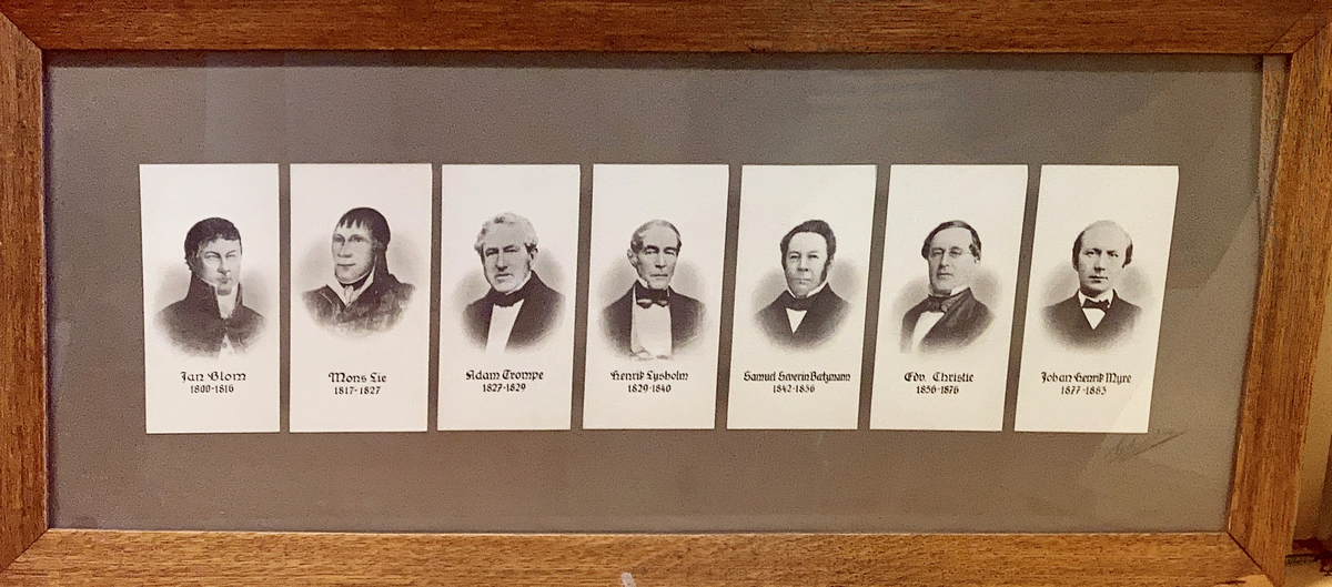 Montasje av sju portretter i glass og ramme.