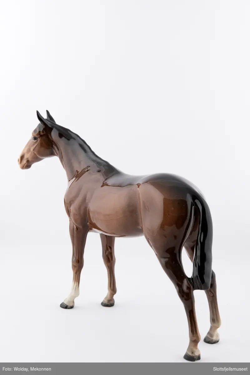 Stående hestefigur i porselen. Kalles Beswick Bois Roussel racehorse. Brun glassert hest med lys mule.
Stemplet med Beswick merket under på magen.