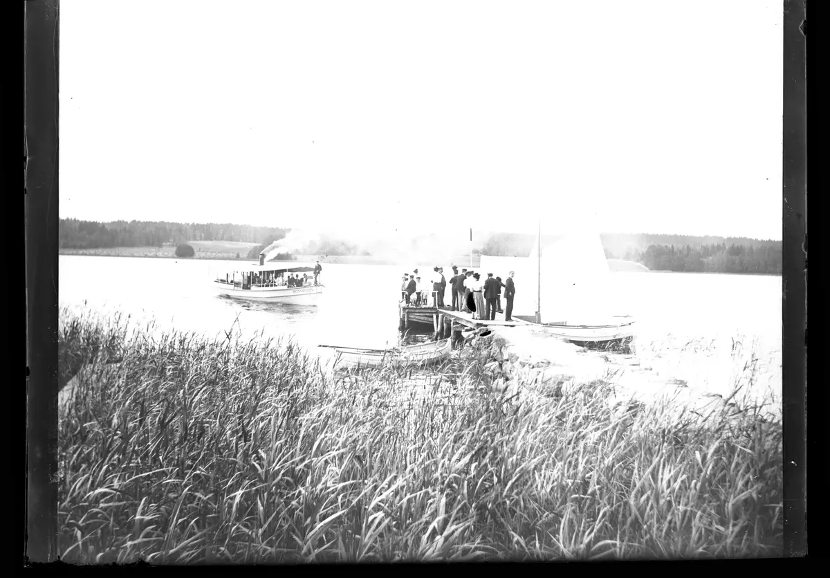 Båten "Brunnsviken" anländer till bryggan vid Sätra äng i Danderyd den 9 juli 1899.
Bilden är troligen tagen av Axel Pehrson.
Glasplåten låg i ett kuvert som hade bildtexten:
"Båten kommer, den 9 juli 1899."