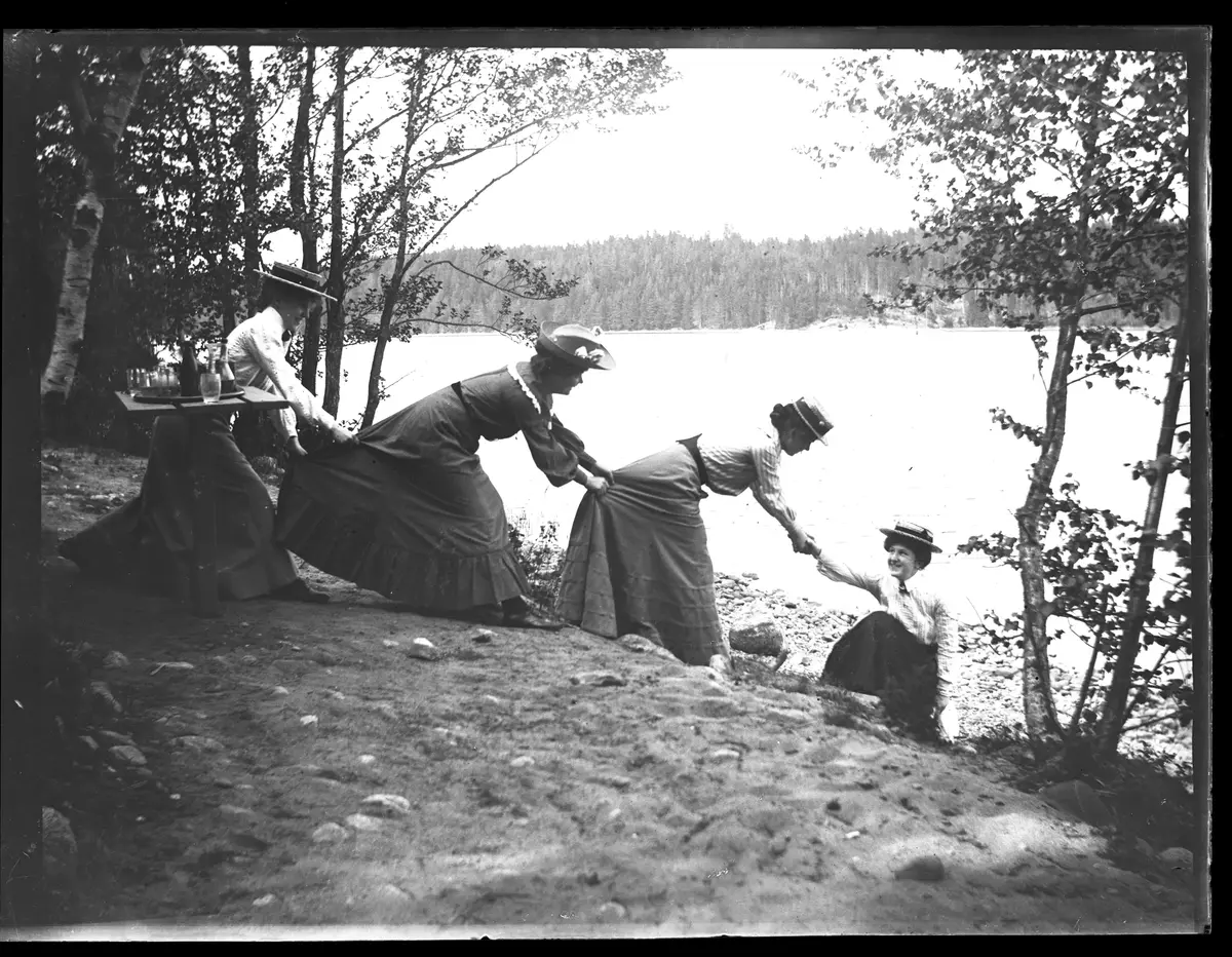 Flickor i långa kjolar vid Edsviken, nära Mörby. Fotot kan vara taget av Axel Pehrson som bodde i Sjöstugan vid Sätra äng. Troligen taget runt 1900.