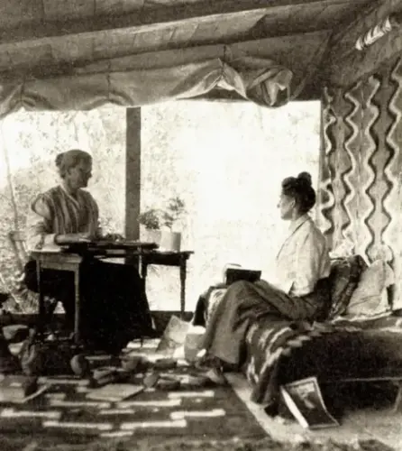 To kvinner på veranda i sofa og ved skrivebort