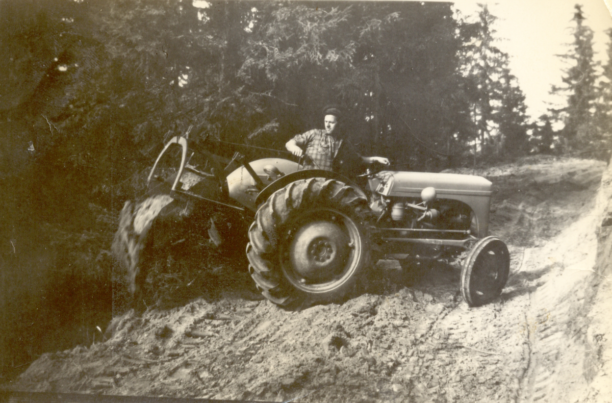 Anleggsarbeid med Ferguson traktor "gråtass" og mollskuff på Gunnesmoen.
Gustav Tomta med traktoren