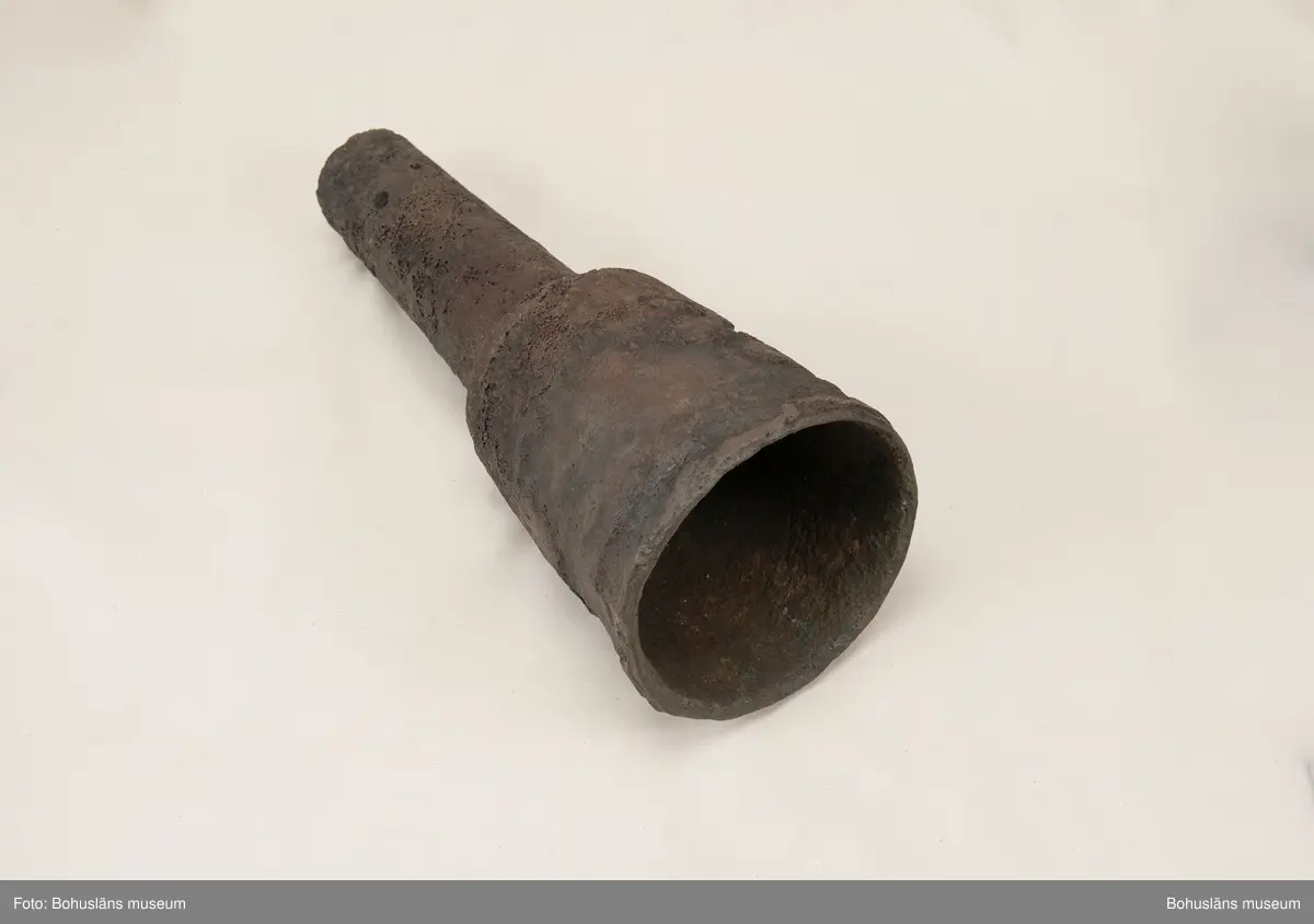 Medeltida bronskanon, s k bombard, gjuten i kraftigt gods. 
Ett sjöfynd upphittat av amatördykare i Marstrandsfjorden. Kanonen kan dateras till 1300-1400-tal. 
Dessa tidiga eldrör göts vanligtvis i brons, d .v.s. en legering av koppar och tenn. Legeringars sammansättning kan dock variera mycket och tidiga exempel finns där, som i detta fallet, tenn bytts ut mot bly och zink. 
Kanonen är 47,5 cm lång, mynningens diameter är 19 cm och den väger ca 18,7 kg. Fänghålet är synligt och har en nuvarande diameter på ca. 1 cm. Rester av en laddning i form av fastkorroderad textil sitter kvar längst in i kanonens rör. Materialet består antingen av hampa eller lintyg. En C14-analys av tyget daterar kanonen till 1300-tal. Krutets sammansättning har inte gått att fastställa.

Artikel ur Populär Arkeologi 2010: "Bombarden från Marstrand" - Vid dykning vid grundet Hannehakarna, väster om Marstrand, fann en sportdykare för några år sedan en märklig tingest, som visade sig vara en liten trattformig bronskanon, 47,5 cm lång och med en mynningsdiameter av 19 cm. Liknande mynningsladdade kanoner, eller bombarder som de kallades, finns bevarade på flera håll runt om i Europa. Vanligen är de dock tillverkade av järn och inte brons. Dateringarna är som regel mycket osäkra, men majoriteten av fynden tycks härröra från 1300- eller 1400-talet.

Fyndplatsen, i anslutning till ett farligt undervattensgrund, talar för att kanonen härrör från en fartygsförlisning. När den påträffades fanns fortfarande en del av laddningen kvar. En kol 14-analys av textilmaterial från laddningen daterar fyndet till 1300-talet.

Marstrandsbombarden utgör därmed ett av de äldsta arkeologiska beläggen för skeppsartilleri i Nordeuropa. Dåtidens artilleriammunition bestod av runda, handknackade kanonkulor av sten. Sådana stenkulor har bland annat bärgats från Skanörskoggen från omkring år 1390. Någon samtida skeppskanon har däremot inte tidigare påträffats."