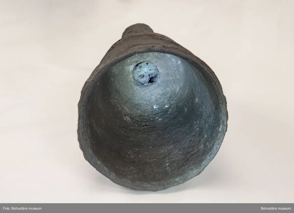Medeltida bronskanon, s k bombard, gjuten i kraftigt gods. 
Ett sjöfynd upphittat av amatördykare i Marstrandsfjorden. Kanonen kan dateras till 1300-1400-tal. 
Dessa tidiga eldrör göts vanligtvis i brons, d .v.s. en legering av koppar och tenn. Legeringars sammansättning kan dock variera mycket och tidiga exempel finns där, som i detta fallet, tenn bytts ut mot bly och zink. 
Kanonen är 47,5 cm lång, mynningens diameter är 19 cm och den väger ca 18,7 kg. Fänghålet är synligt och har en nuvarande diameter på ca. 1 cm. Rester av en laddning i form av fastkorroderad textil sitter kvar längst in i kanonens rör. Materialet består antingen av hampa eller lintyg. En C14-analys av tyget daterar kanonen till 1300-tal. Krutets sammansättning har inte gått att fastställa.

Artikel ur Populär Arkeologi 2010: "Bombarden från Marstrand" - Vid dykning vid grundet Hannehakarna, väster om Marstrand, fann en sportdykare för några år sedan en märklig tingest, som visade sig vara en liten trattformig bronskanon, 47,5 cm lång och med en mynningsdiameter av 19 cm. Liknande mynningsladdade kanoner, eller bombarder som de kallades, finns bevarade på flera håll runt om i Europa. Vanligen är de dock tillverkade av järn och inte brons. Dateringarna är som regel mycket osäkra, men majoriteten av fynden tycks härröra från 1300- eller 1400-talet.

Fyndplatsen, i anslutning till ett farligt undervattensgrund, talar för att kanonen härrör från en fartygsförlisning. När den påträffades fanns fortfarande en del av laddningen kvar. En kol 14-analys av textilmaterial från laddningen daterar fyndet till 1300-talet.

Marstrandsbombarden utgör därmed ett av de äldsta arkeologiska beläggen för skeppsartilleri i Nordeuropa. Dåtidens artilleriammunition bestod av runda, handknackade kanonkulor av sten. Sådana stenkulor har bland annat bärgats från Skanörskoggen från omkring år 1390. Någon samtida skeppskanon har däremot inte tidigare påträffats."