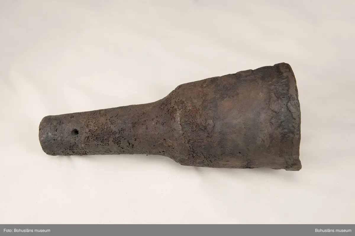 Medeltida bronskanon, s k bombard, gjuten i kraftigt gods. 
Ett sjöfynd upphittat av amatördykare i Marstrandsfjorden. Kanonen kan dateras till 1300-1400-tal. 
Dessa tidiga eldrör göts vanligtvis i brons, d .v.s. en legering av koppar och tenn. Legeringars sammansättning kan dock variera mycket och tidiga exempel finns där, som i detta fallet, tenn bytts ut mot bly och zink. 
Kanonen är 47,5 cm lång, mynningens diameter är 19 cm och den väger ca 18,7 kg. Fänghålet är synligt och har en nuvarande diameter på ca. 1 cm. Rester av en laddning i form av fastkorroderad textil sitter kvar längst in i kanonens rör. Materialet består antingen av hampa eller lintyg. En C14-analys av tyget daterar kanonen till 1300-tal. Krutets sammansättning har inte gått att fastställa.

Artikel ur Populär Arkeologi 2010: "Bombarden från Marstrand" - Vid dykning vid grundet Hannehakarna, väster om Marstrand, fann en sportdykare för några år sedan en märklig tingest, som visade sig vara en liten trattformig bronskanon, 47,5 cm lång och med en mynningsdiameter av 19 cm. Liknande mynningsladdade kanoner, eller bombarder som de kallades, finns bevarade på flera håll runt om i Europa. Vanligen är de dock tillverkade av järn och inte brons. Dateringarna är som regel mycket osäkra, men majoriteten av fynden tycks härröra från 1300- eller 1400-talet.

Fyndplatsen, i anslutning till ett farligt undervattensgrund, talar för att kanonen härrör från en fartygsförlisning. När den påträffades fanns fortfarande en del av laddningen kvar. En kol 14-analys av textilmaterial från laddningen daterar fyndet till 1300-talet.

Marstrandsbombarden utgör därmed ett av de äldsta arkeologiska beläggen för skeppsartilleri i Nordeuropa. Dåtidens artilleriammunition bestod av runda, handknackade kanonkulor av sten. Sådana stenkulor har bland annat bärgats från Skanörskoggen från omkring år 1390. Någon samtida skeppskanon har däremot inte tidigare påträffats."