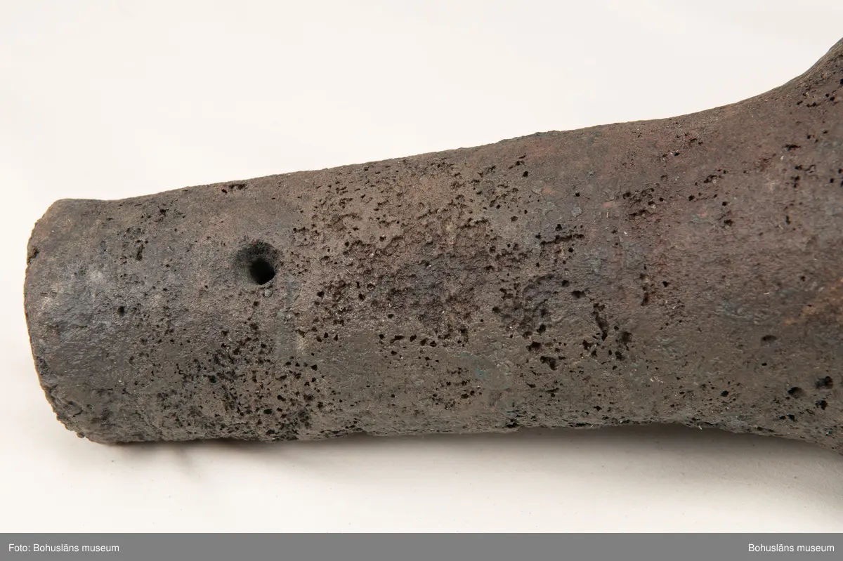 Medeltida bronskanon, s k bombard, gjuten i kraftigt gods. 
Ett sjöfynd upphittat av amatördykare i Marstrandsfjorden. Kanonen kan dateras till 1300-1400-tal. 
Dessa tidiga eldrör göts vanligtvis i brons, d .v.s. en legering av koppar och tenn. Legeringars sammansättning kan dock variera mycket och tidiga exempel finns där, som i detta fallet, tenn bytts ut mot bly och zink. 
Kanonen är 47,5 cm lång, mynningens diameter är 19 cm och den väger ca 18,7 kg. Fänghålet är synligt och har en nuvarande diameter på ca. 1 cm. Rester av en laddning i form av fastkorroderad textil sitter kvar längst in i kanonens rör. Materialet består antingen av hampa eller lintyg. En C14-analys av tyget daterar kanonen till 1300-tal. Krutets sammansättning har inte gått att fastställa.

Artikel ur Populär Arkeologi 2010: "Bombarden från Marstrand" - Vid dykning vid grundet Hannehakarna, väster om Marstrand, fann en sportdykare för några år sedan en märklig tingest, som visade sig vara en liten trattformig bronskanon, 47,5 cm lång och med en mynningsdiameter av 19 cm. Liknande mynningsladdade kanoner, eller bombarder som de kallades, finns bevarade på flera håll runt om i Europa. Vanligen är de dock tillverkade av järn och inte brons. Dateringarna är som regel mycket osäkra, men majoriteten av fynden tycks härröra från 1300- eller 1400-talet.

Fyndplatsen, i anslutning till ett farligt undervattensgrund, talar för att kanonen härrör från en fartygsförlisning. När den påträffades fanns fortfarande en del av laddningen kvar. En kol 14-analys av textilmaterial från laddningen daterar fyndet till 1300-talet.

Marstrandsbombarden utgör därmed ett av de äldsta arkeologiska beläggen för skeppsartilleri i Nordeuropa. Dåtidens artilleriammunition bestod av runda, handknackade kanonkulor av sten. Sådana stenkulor har bland annat bärgats från Skanörskoggen från omkring år 1390. Någon samtida skeppskanon har däremot inte tidigare påträffats."