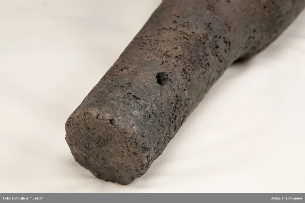 Medeltida bronskanon, s k bombard, gjuten i kraftigt gods. 
Ett sjöfynd upphittat av amatördykare i Marstrandsfjorden. Kanonen kan dateras till 1300-1400-tal. 
Dessa tidiga eldrör göts vanligtvis i brons, d .v.s. en legering av koppar och tenn. Legeringars sammansättning kan dock variera mycket och tidiga exempel finns där, som i detta fallet, tenn bytts ut mot bly och zink. 
Kanonen är 47,5 cm lång, mynningens diameter är 19 cm och den väger ca 18,7 kg. Fänghålet är synligt och har en nuvarande diameter på ca. 1 cm. Rester av en laddning i form av fastkorroderad textil sitter kvar längst in i kanonens rör. Materialet består antingen av hampa eller lintyg. En C14-analys av tyget daterar kanonen till 1300-tal. Krutets sammansättning har inte gått att fastställa.

Artikel ur Populär Arkeologi 2010: "Bombarden från Marstrand" - Vid dykning vid grundet Hannehakarna, väster om Marstrand, fann en sportdykare för några år sedan en märklig tingest, som visade sig vara en liten trattformig bronskanon, 47,5 cm lång och med en mynningsdiameter av 19 cm. Liknande mynningsladdade kanoner, eller bombarder som de kallades, finns bevarade på flera håll runt om i Europa. Vanligen är de dock tillverkade av järn och inte brons. Dateringarna är som regel mycket osäkra, men majoriteten av fynden tycks härröra från 1300- eller 1400-talet.

Fyndplatsen, i anslutning till ett farligt undervattensgrund, talar för att kanonen härrör från en fartygsförlisning. När den påträffades fanns fortfarande en del av laddningen kvar. En kol 14-analys av textilmaterial från laddningen daterar fyndet till 1300-talet.

Marstrandsbombarden utgör därmed ett av de äldsta arkeologiska beläggen för skeppsartilleri i Nordeuropa. Dåtidens artilleriammunition bestod av runda, handknackade kanonkulor av sten. Sådana stenkulor har bland annat bärgats från Skanörskoggen från omkring år 1390. Någon samtida skeppskanon har däremot inte tidigare påträffats."