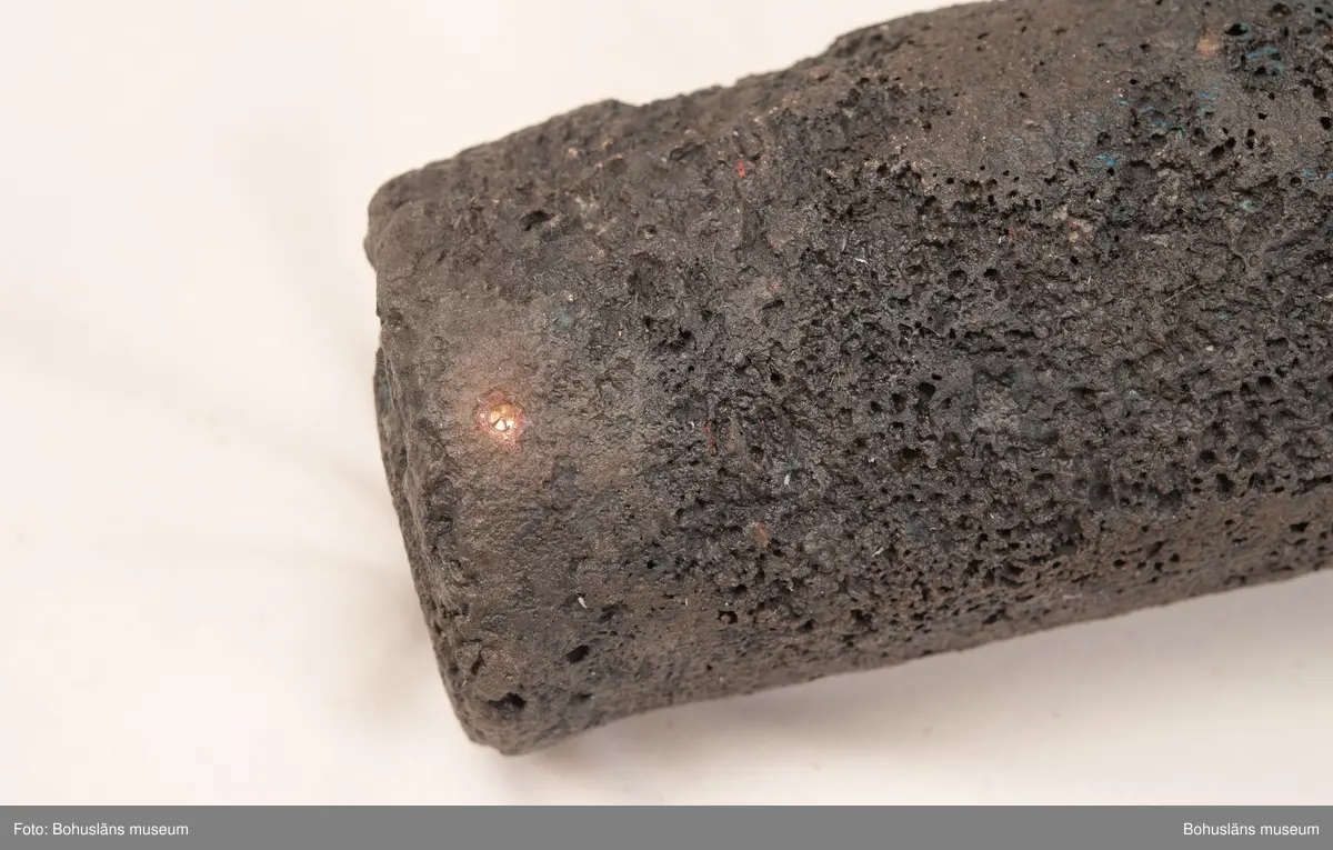 Medeltida bronskanon, s k bombard, gjuten i kraftigt gods. 
Ett sjöfynd upphittat av amatördykare i Marstrandsfjorden. Kanonen kan dateras till 1300-1400-tal. 
Dessa tidiga eldrör göts vanligtvis i brons, d .v.s. en legering av koppar och tenn. Legeringars sammansättning kan dock variera mycket och tidiga exempel finns där, som i detta fallet, tenn bytts ut mot bly och zink. 
Kanonen är 47,5 cm lång, mynningens diameter är 19 cm och den väger ca 18,7 kg. Fänghålet är synligt och har en nuvarande diameter på ca. 1 cm. Rester av en laddning i form av fastkorroderad textil sitter kvar längst in i kanonens rör. Materialet består antingen av hampa eller lintyg. En C14-analys av tyget daterar kanonen till 1300-tal. Krutets sammansättning har inte gått att fastställa.

Artikel ur Populär Arkeologi 2010: "Bombarden från Marstrand" - Vid dykning vid grundet Hannehakarna, väster om Marstrand, fann en sportdykare för några år sedan en märklig tingest, som visade sig vara en liten trattformig bronskanon, 47,5 cm lång och med en mynningsdiameter av 19 cm. Liknande mynningsladdade kanoner, eller bombarder som de kallades, finns bevarade på flera håll runt om i Europa. Vanligen är de dock tillverkade av järn och inte brons. Dateringarna är som regel mycket osäkra, men majoriteten av fynden tycks härröra från 1300- eller 1400-talet.

Fyndplatsen, i anslutning till ett farligt undervattensgrund, talar för att kanonen härrör från en fartygsförlisning. När den påträffades fanns fortfarande en del av laddningen kvar. En kol 14-analys av textilmaterial från laddningen daterar fyndet till 1300-talet.

Marstrandsbombarden utgör därmed ett av de äldsta arkeologiska beläggen för skeppsartilleri i Nordeuropa. Dåtidens artilleriammunition bestod av runda, handknackade kanonkulor av sten. Sådana stenkulor har bland annat bärgats från Skanörskoggen från omkring år 1390. Någon samtida skeppskanon har däremot inte tidigare påträffats."