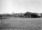 Begynnande höst 1921 och jordbruksårets fart har saktat in på hemmanet Gunnarsbo. Den präktiga höstacken invid ladugården skvallrar om ett gott odlingsår. Det kunde behövas, genom en uppteckning från gården får vi veta att hemmanet bar så kallat mjölkarrende mot godset Bjärka Säby på inte mindre än 6 000 liter mjölk om året. Vid tiden för bilden brukades gården av Didrik Emil Karlsson och dennes maka Hilma Sofia Nilsson.